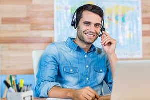 Handsome travel agent smiling at camera in the office